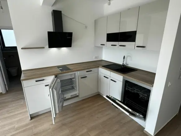 Contemporary L-shaped kitchen in Ulcinj: white cabinets, wood countertops, eco features&mdash;prime investment at immobilien.ekosphere.me by Ekosphere.