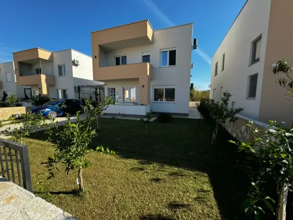 Stylish modern two-story home in Ulcinj, Montenegro with large windows, balcony & manicured lawn&mdash;listed by immobilien.ekosphere.me.