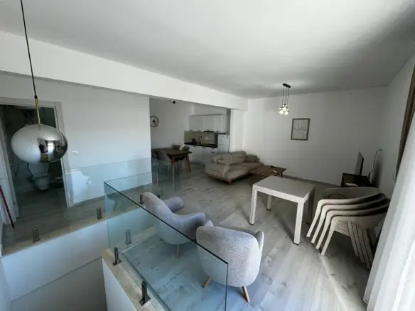 Stylish Ulcinj home: light wood floors, gray armchairs, beige sofa, glass stairway&mdash;exclusive at immobilien.ekosphere.me by ekosphere doo.