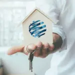 Discover investment potential in Ulcinj, Montenegro—wooden house model with globe and keys. Montenegro-listings.me by ekosphere doo.