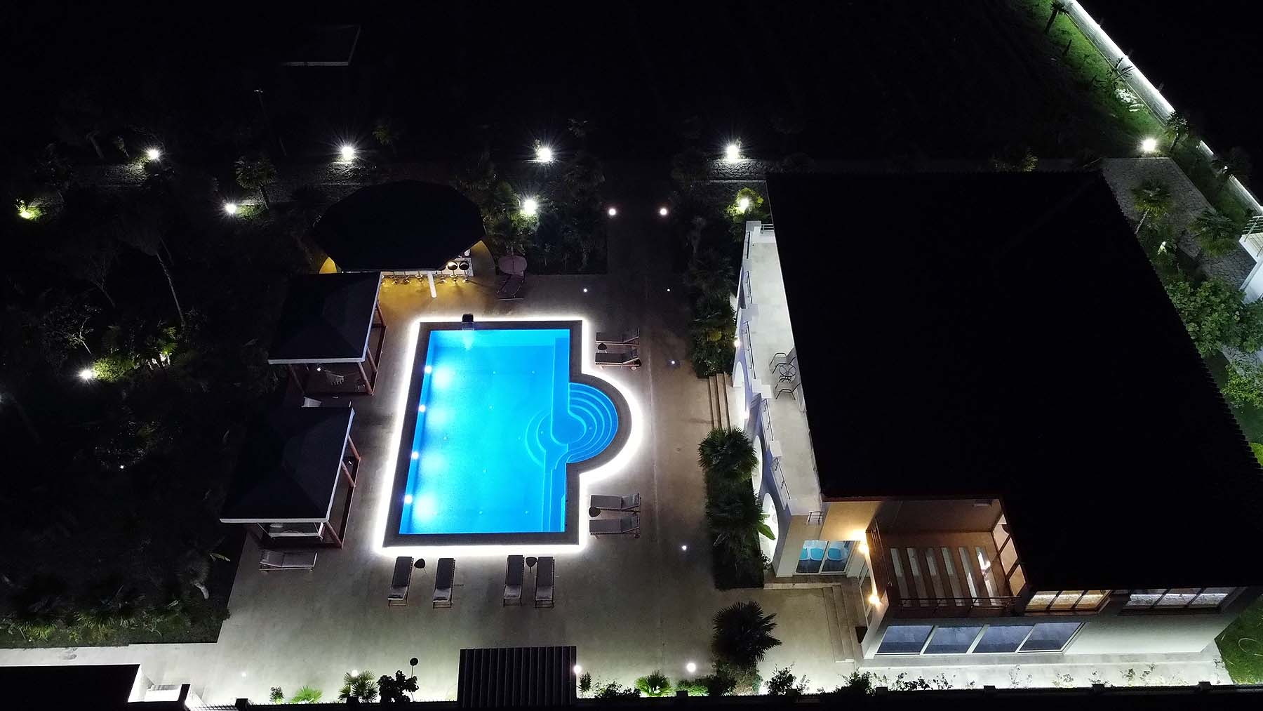 Luxurious illuminated pool with cabanas and lounge area at premium Ulcinj property&mdash;exclusive on immobilien.ekosphere.me by Ekosphere doo.