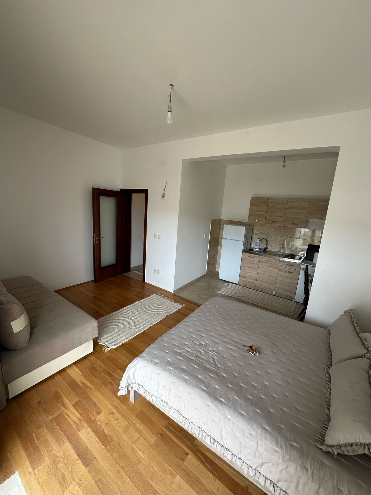 Modern studio apartment in Ulcinj, Montenegro&mdash;wood floors, open kitchenette&mdash;ideal investment via immobilien.ekosphere.me by Ekosphere.