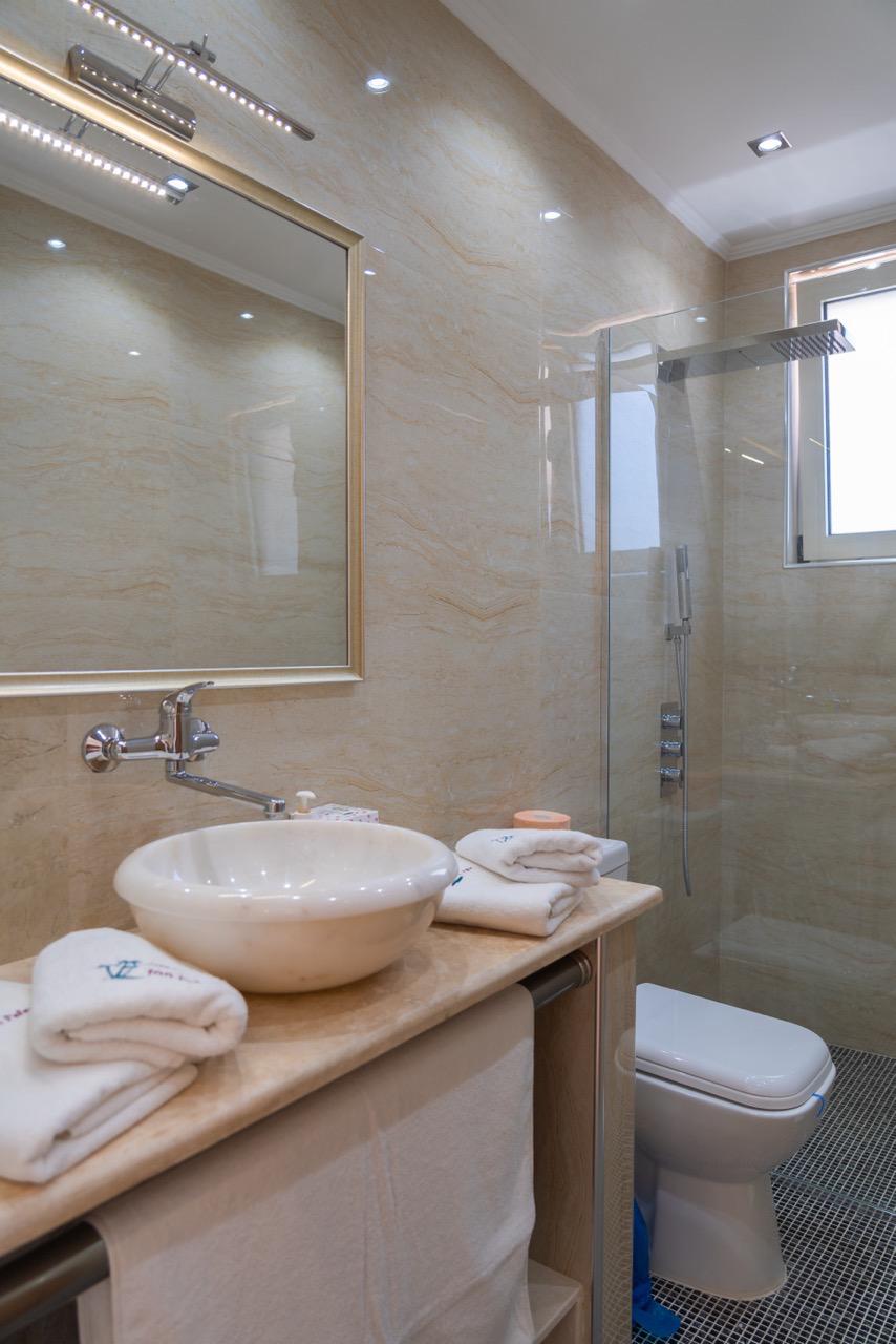 Elegant modern bathroom with beige marble, premium fixtures, in top Ulcinj real estate. Invest via immobilien.ekosphere.me by ekosphere doo.