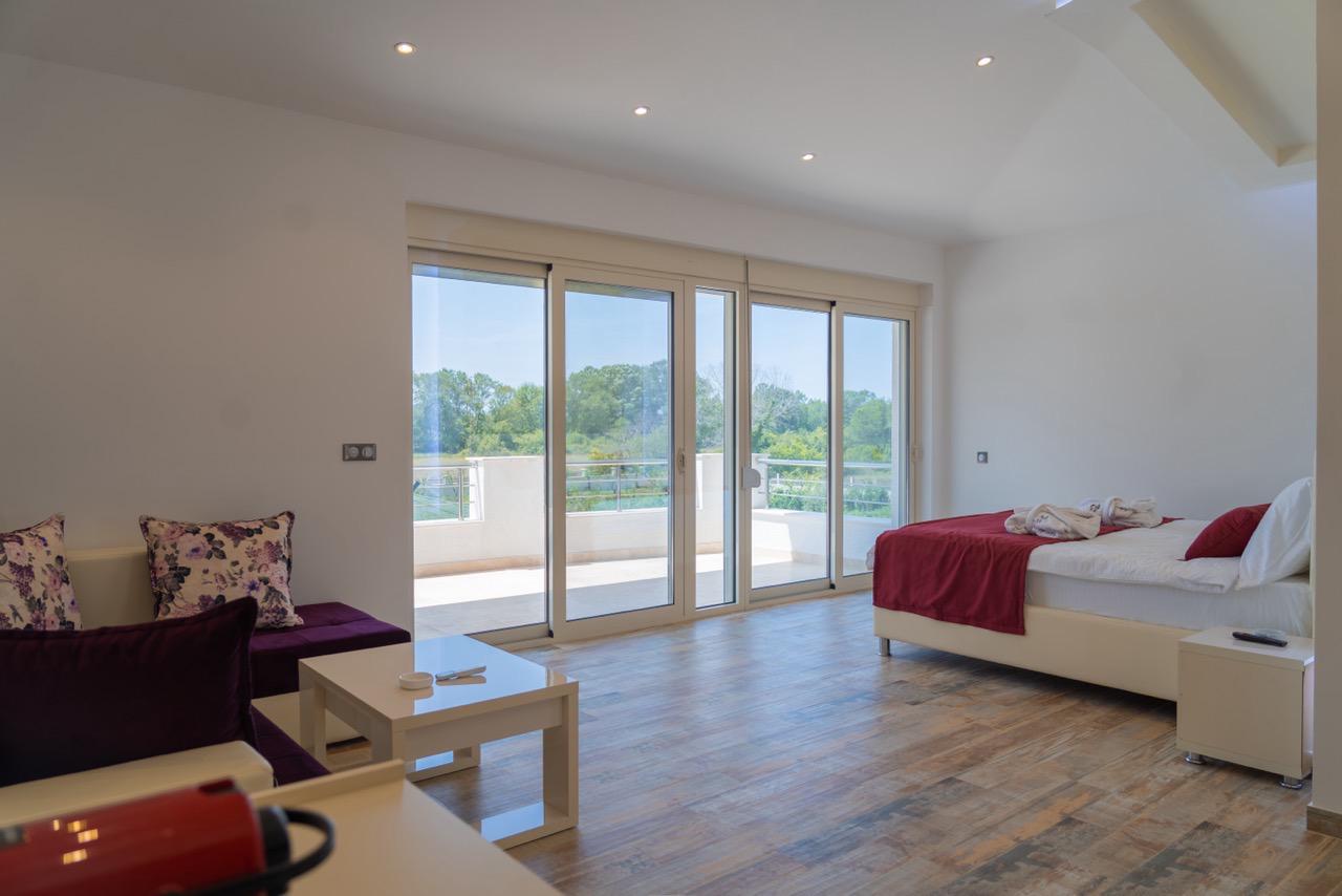 Stunning modern room in Ulcinj, Montenegro&mdash;spacious, wood floors, stylish sofa, balcony views. Exclusive on immobilien.ekosphere.me by Ekosphere doo.