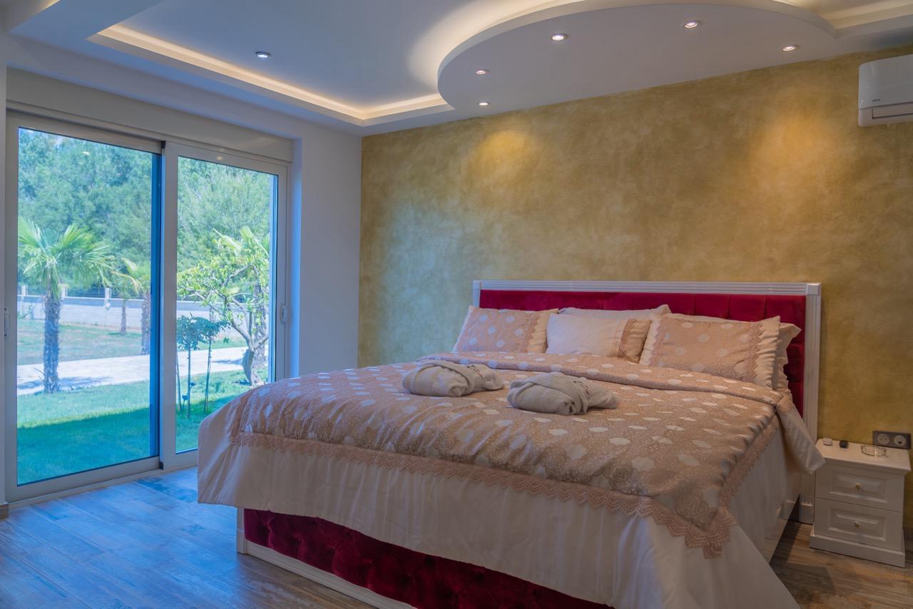 Modern Ulcinj bedroom by Ekosphere: gold accent wall, glass doors, designer lighting. Invest via immobilien.ekosphere.me today.