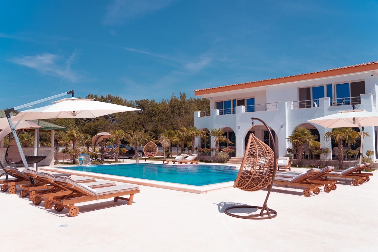 Luxurious modern villa with pool, lush palms, and spacious balconies in Ulcinj&mdash;exclusive Ekosphere DOO listing on immobilien.ekosphere.me.