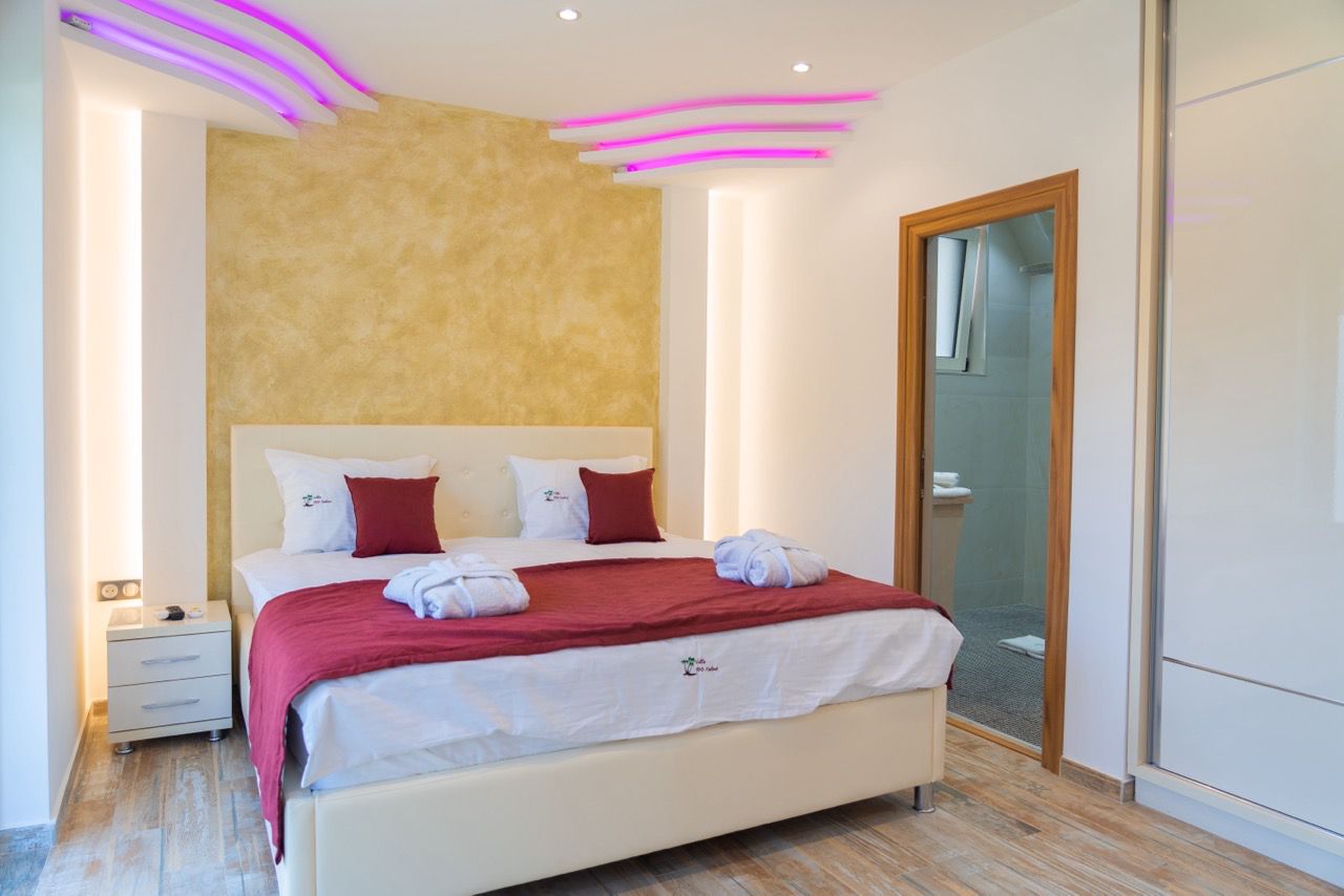 Stylish Ulcinj hotel room with luxury bed, chic lighting, gold accent wall, and ensuite&mdash;ideal for property investors via immobilien.ekosphere.me by ekosphere doo.