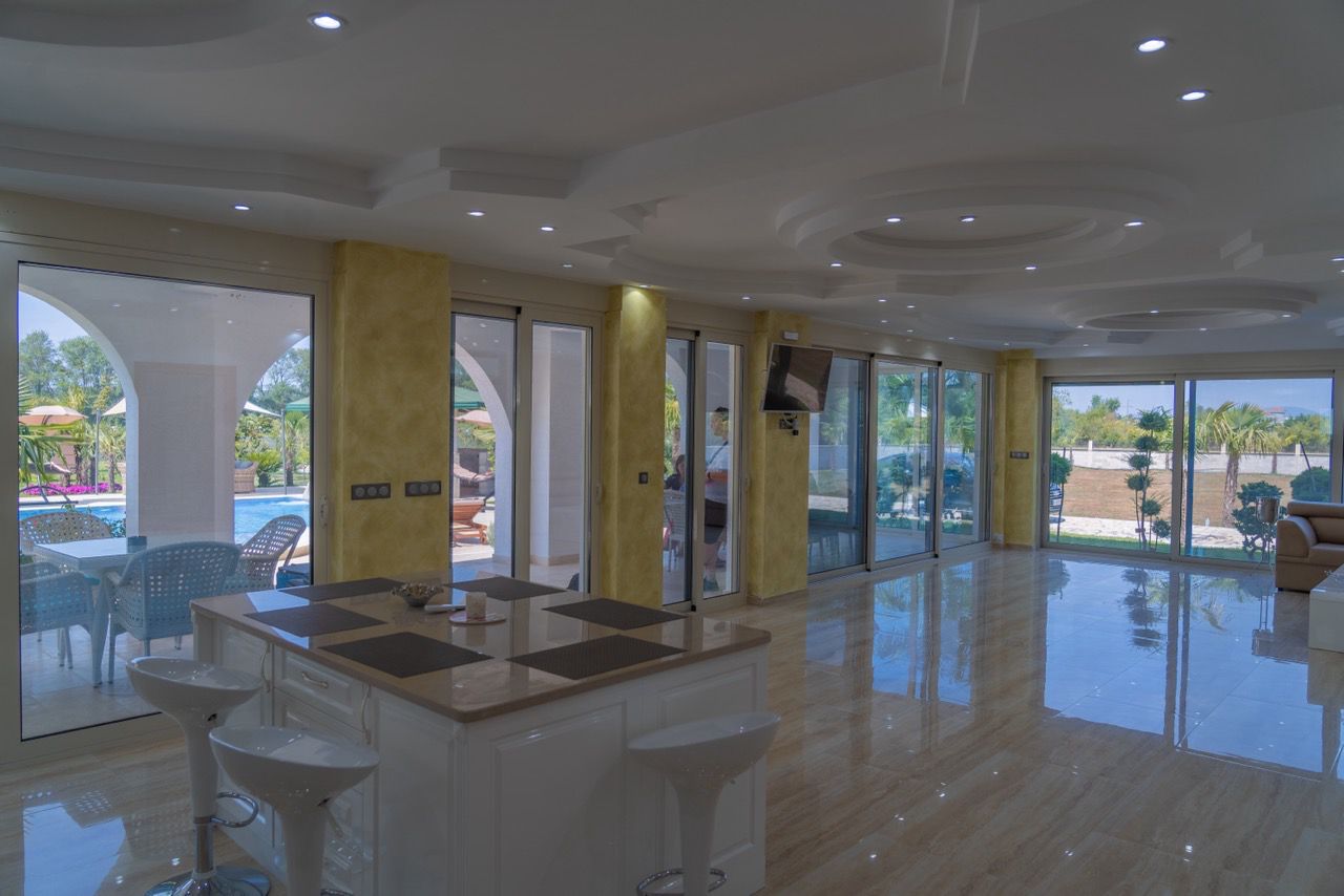 Luxury Ulcinj home with marble floors, open living space, pool view, and kitchen island&mdash;exclusive Ekosphere listing on immobilien.ekosphere.me.