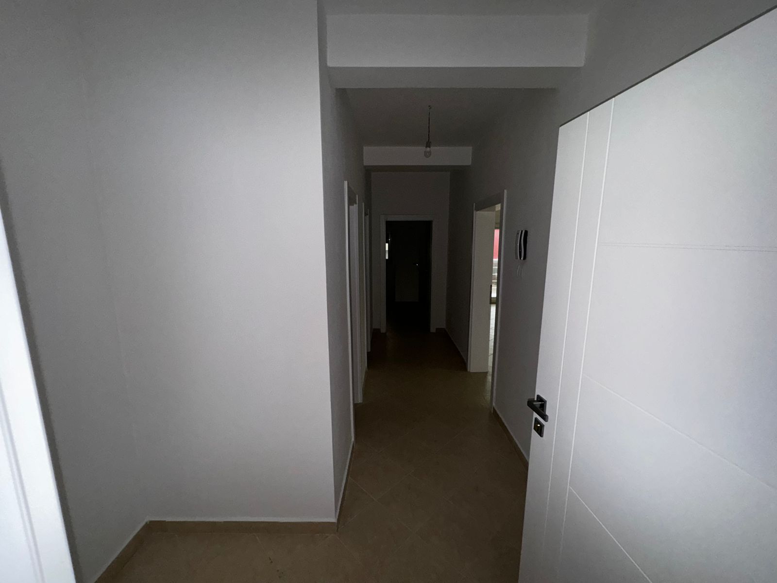 Spacious hallway with white walls, beige tile floors, and multiple doors&mdash;ideal Ulcinj property by ekosphere doo on immobilien.ekosphere.me.