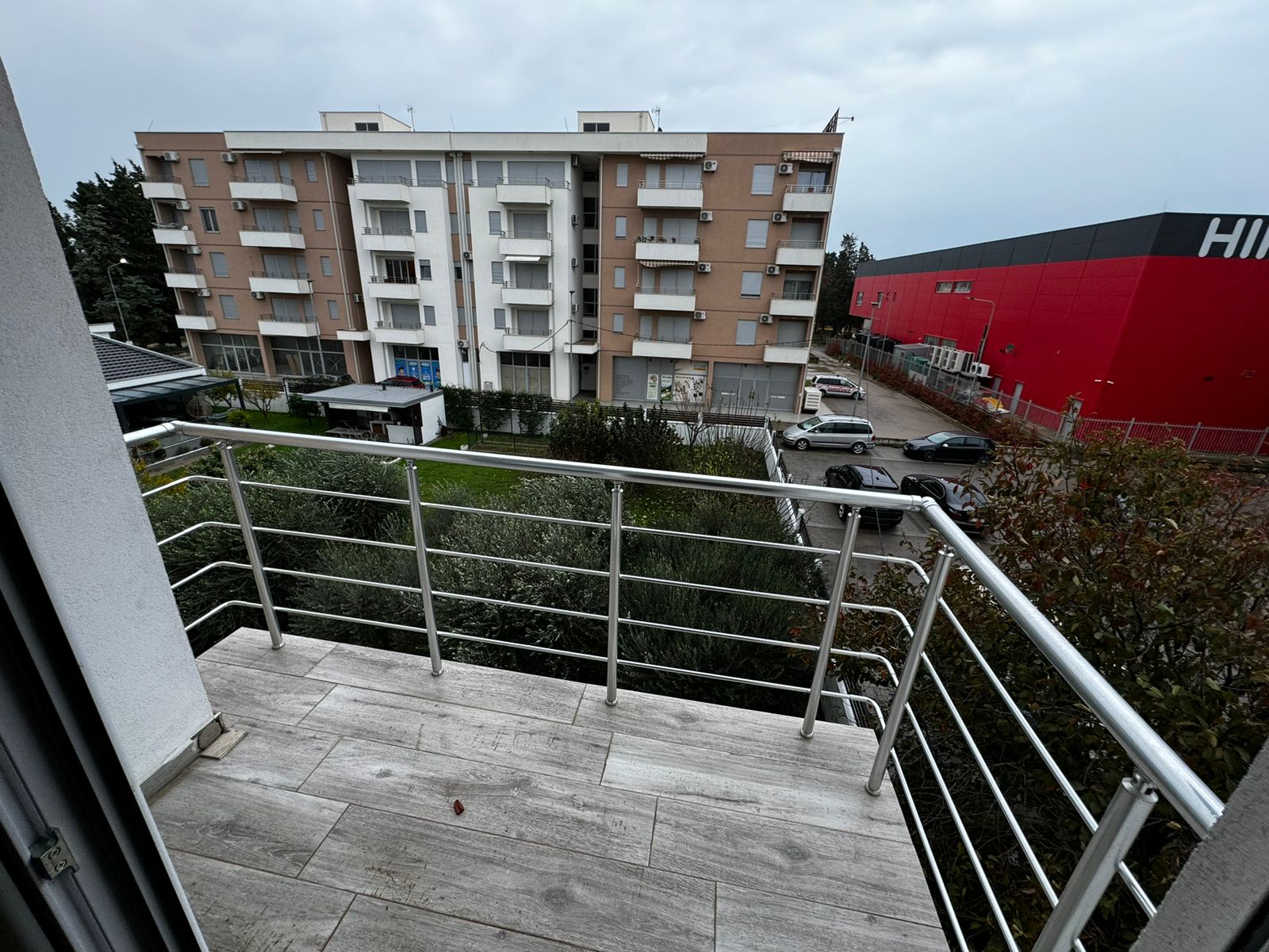 Modern tiled balcony with metal railings, city views of Ulcinj, Montenegro. Prime real estate near ekosphere doo. Invest today!.