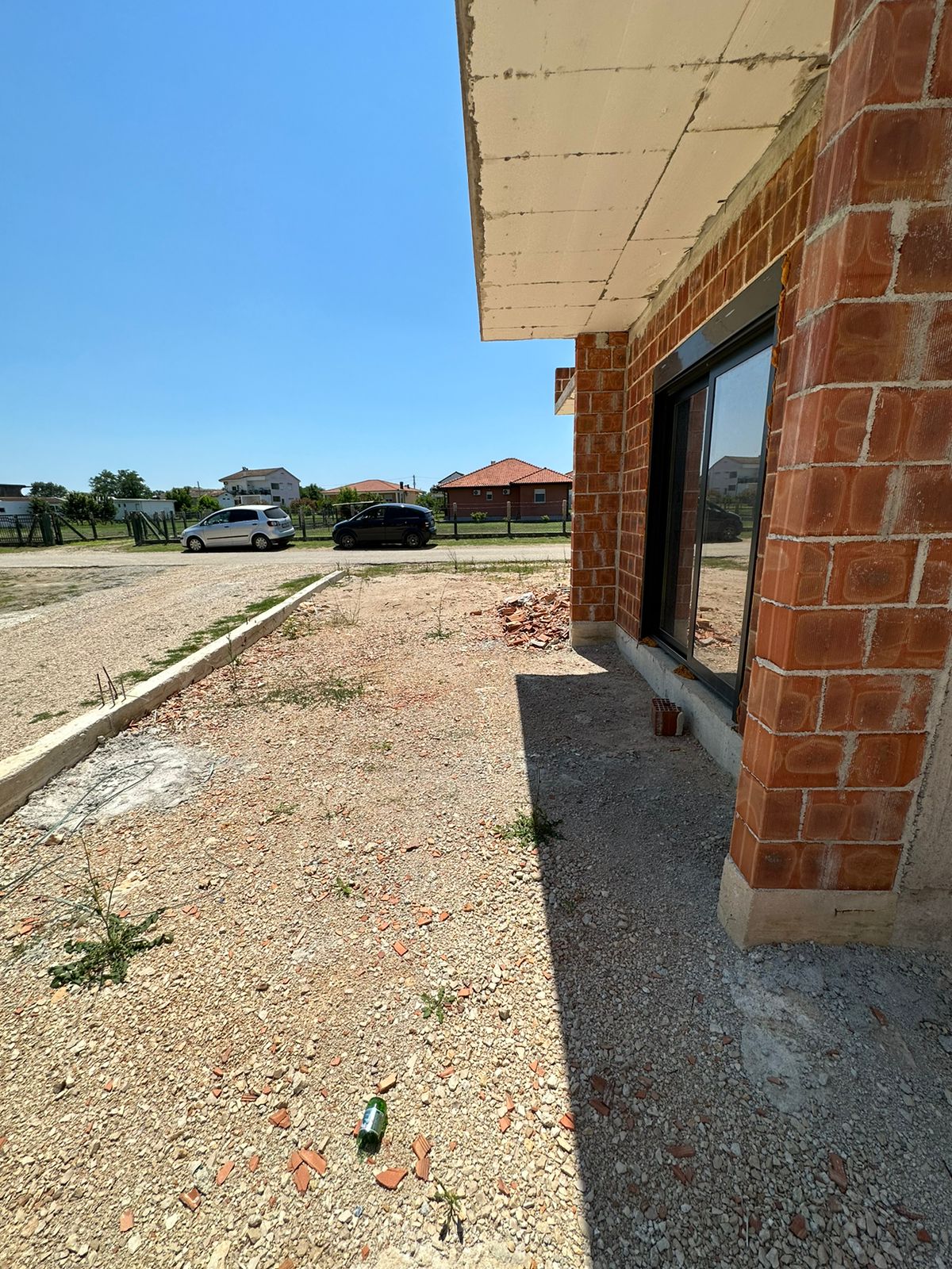 Modern brick building by Ekosphere with glass doors, gravel yard, and Ulcinj real estate views&mdash;exclusive at immobilien.ekosphere.me.