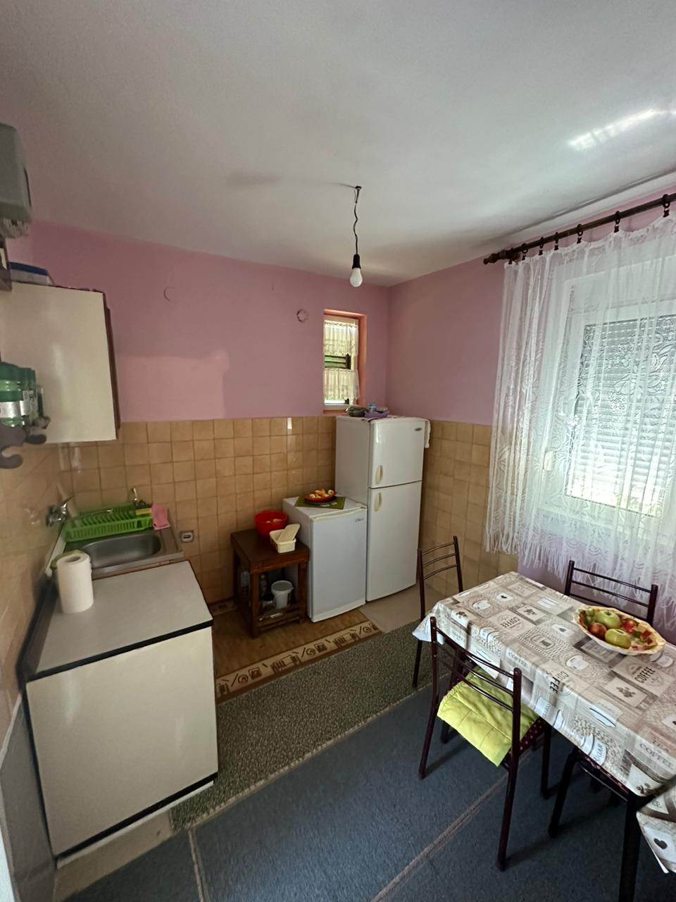 Charming Ulcinj kitchen with pink walls, brown tiles, appliances, dining set&mdash;ideal investment. Exclusive at immobilien.ekosphere.me by ekosphere doo.