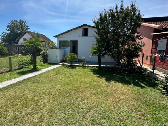 Charming white house with glass door on lush lawn, prime Ulcinj location near amenities&mdash;exclusive at immobilien.ekosphere.me by ekosphere doo.