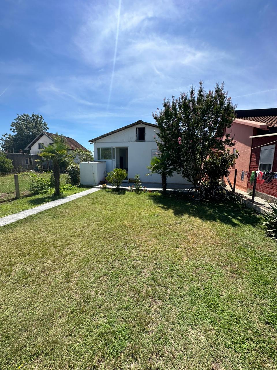 Charming white house with glass door on lush lawn, prime Ulcinj location near amenities&mdash;exclusive at immobilien.ekosphere.me by ekosphere doo.