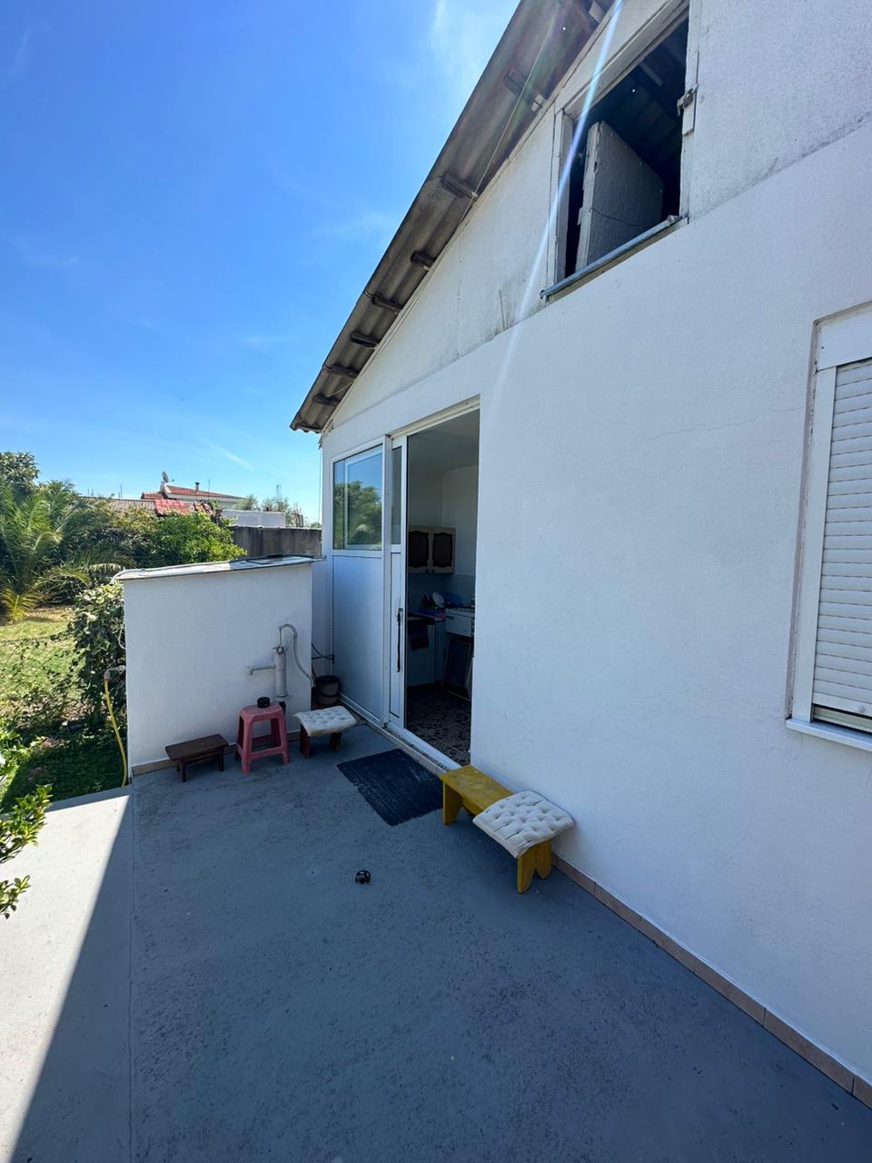 Sunny patio in Ulcinj, Montenegro with stylish seating, sliding glass door, and ekosphere-inspired interior&mdash;exclusive on immobilien.ekosphere.me.