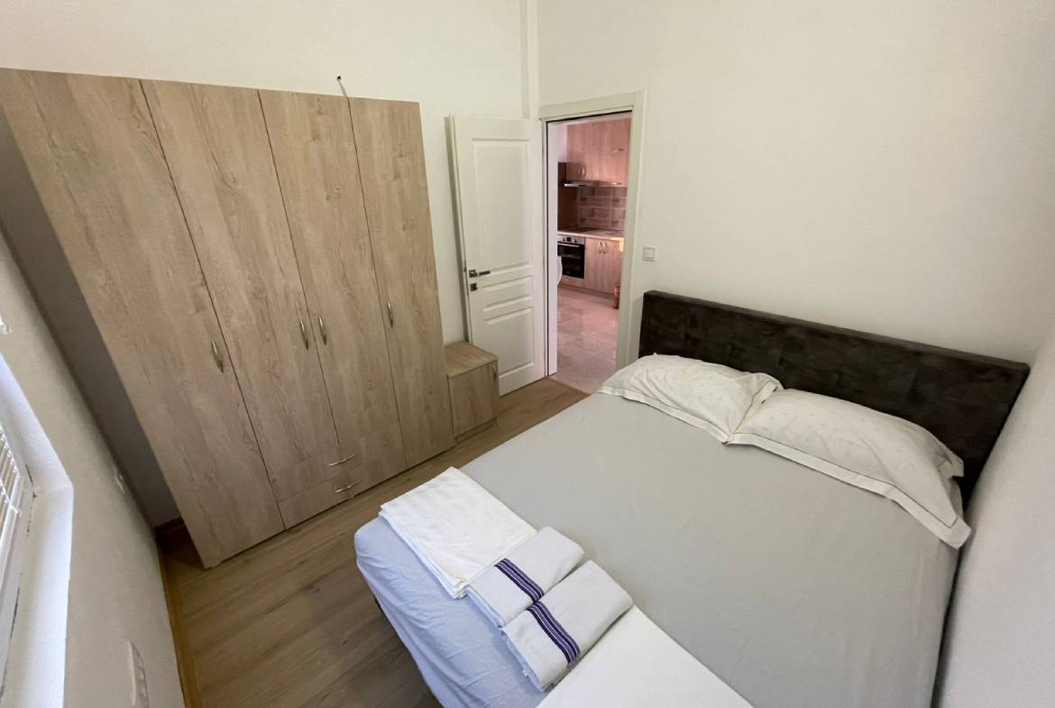 Charming Ulcinj Montenegro property: stylish small bedroom with wood floors, double bed, wardrobe&mdash;ideal investment at immobilien.ekosphere.me by ekosphere doo.