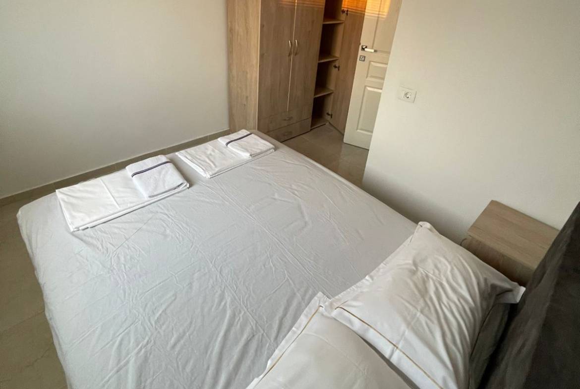 Bright, minimal Ulcinj bedroom with a neat bed, wardrobe, and closet&mdash;exclusive on immobilien.ekosphere.me by ekosphere doo.