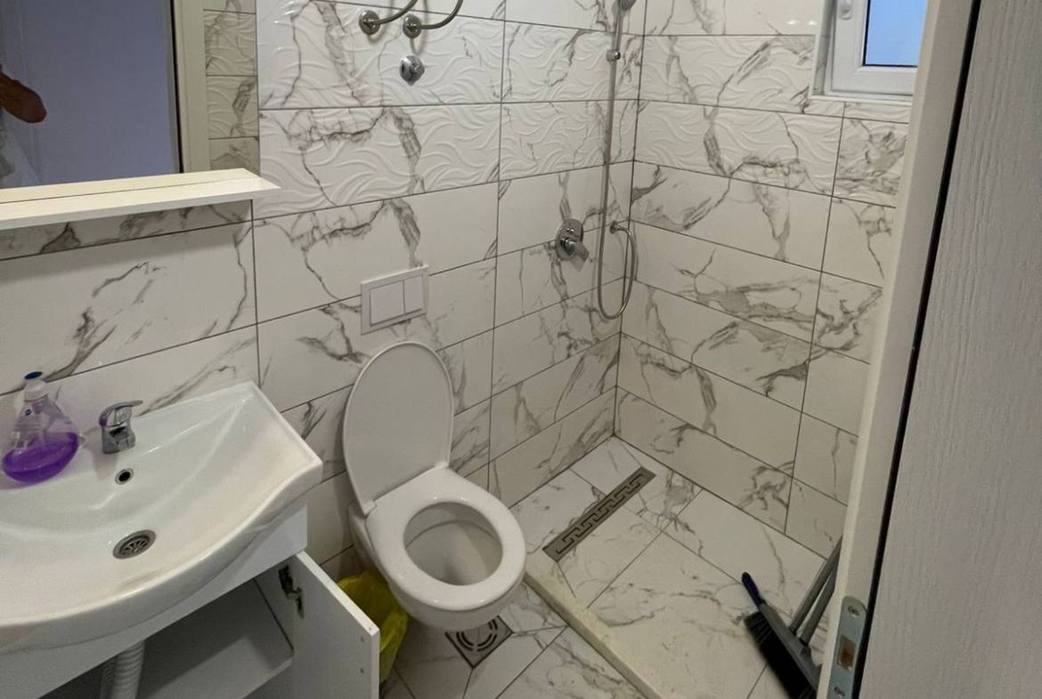 Modern small bathroom in Ulcinj property with marble tiles, walk-in shower; invest via immobilien.ekosphere.me by ekosphere doo.