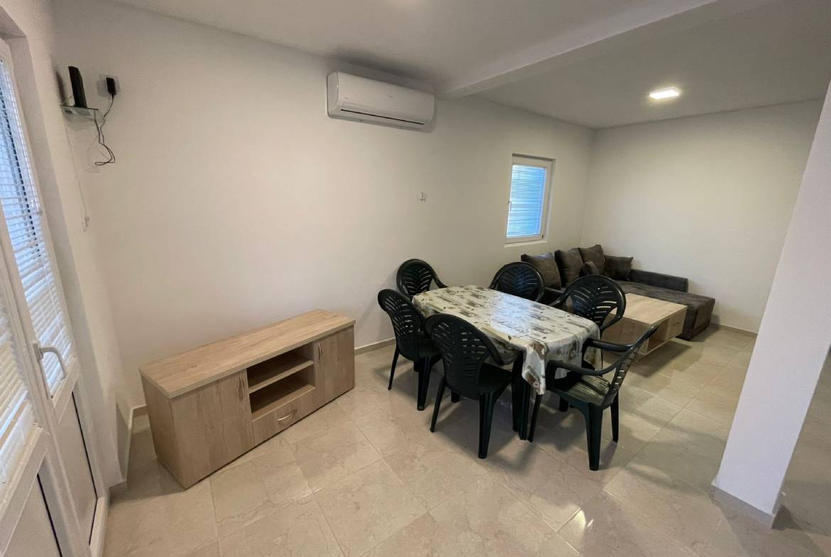 Modern open-plan living/dining in Ulcinj, Montenegro: tiled floors, gray sofa, AC&mdash;prime investment at immobilien.ekosphere.me by ekosphere doo.