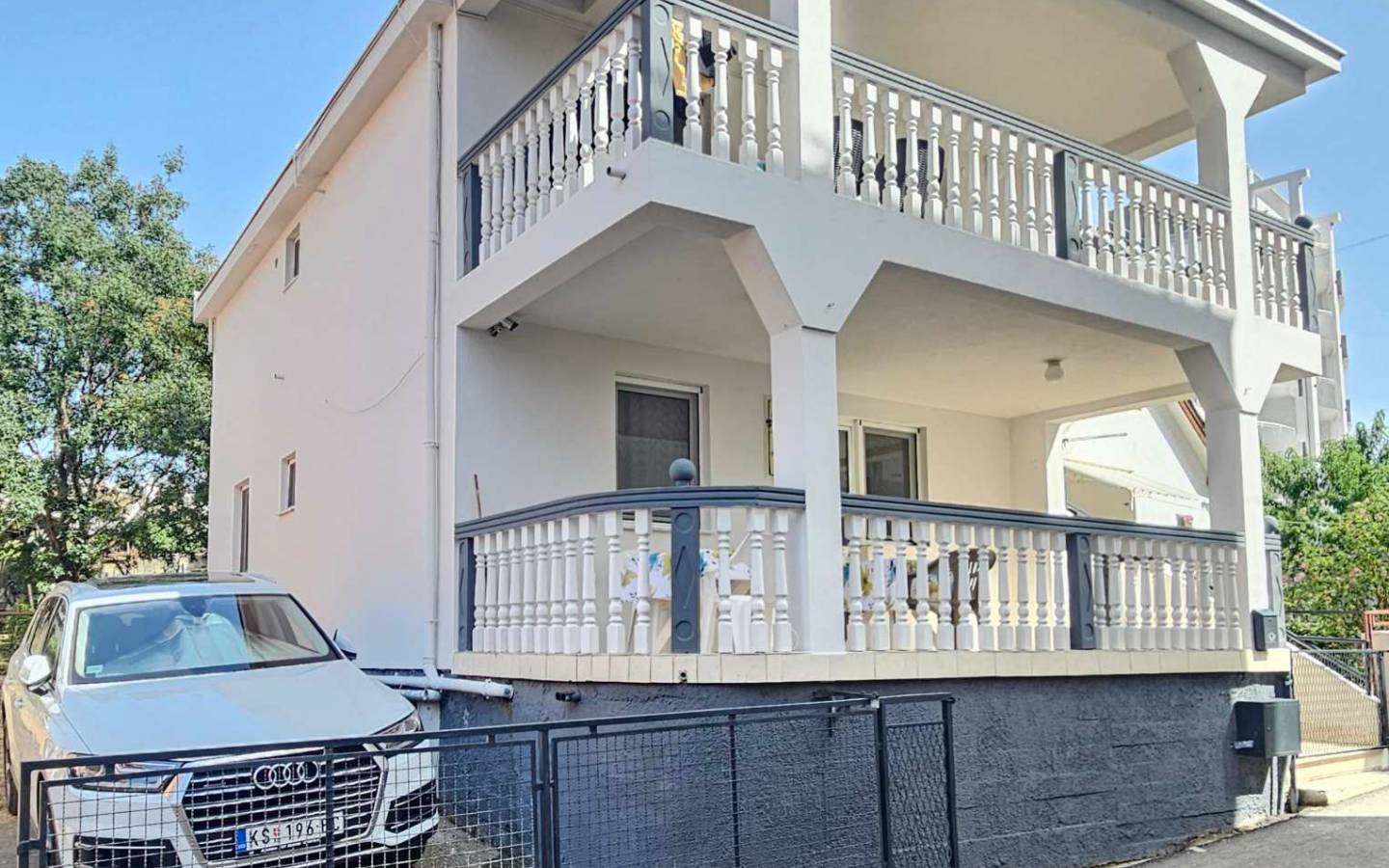 Elegantes wei&szlig;es zweist&ouml;ckiges Haus mit ger&auml;umigem Balkon, hochwertigem Zaun, &uuml;ppigem Gr&uuml;n und Einfahrt - eine erstklassige Immobilieninvestition in Ulcinj &uuml;ber immobilien.ekosphere.me by ekosphere doo.