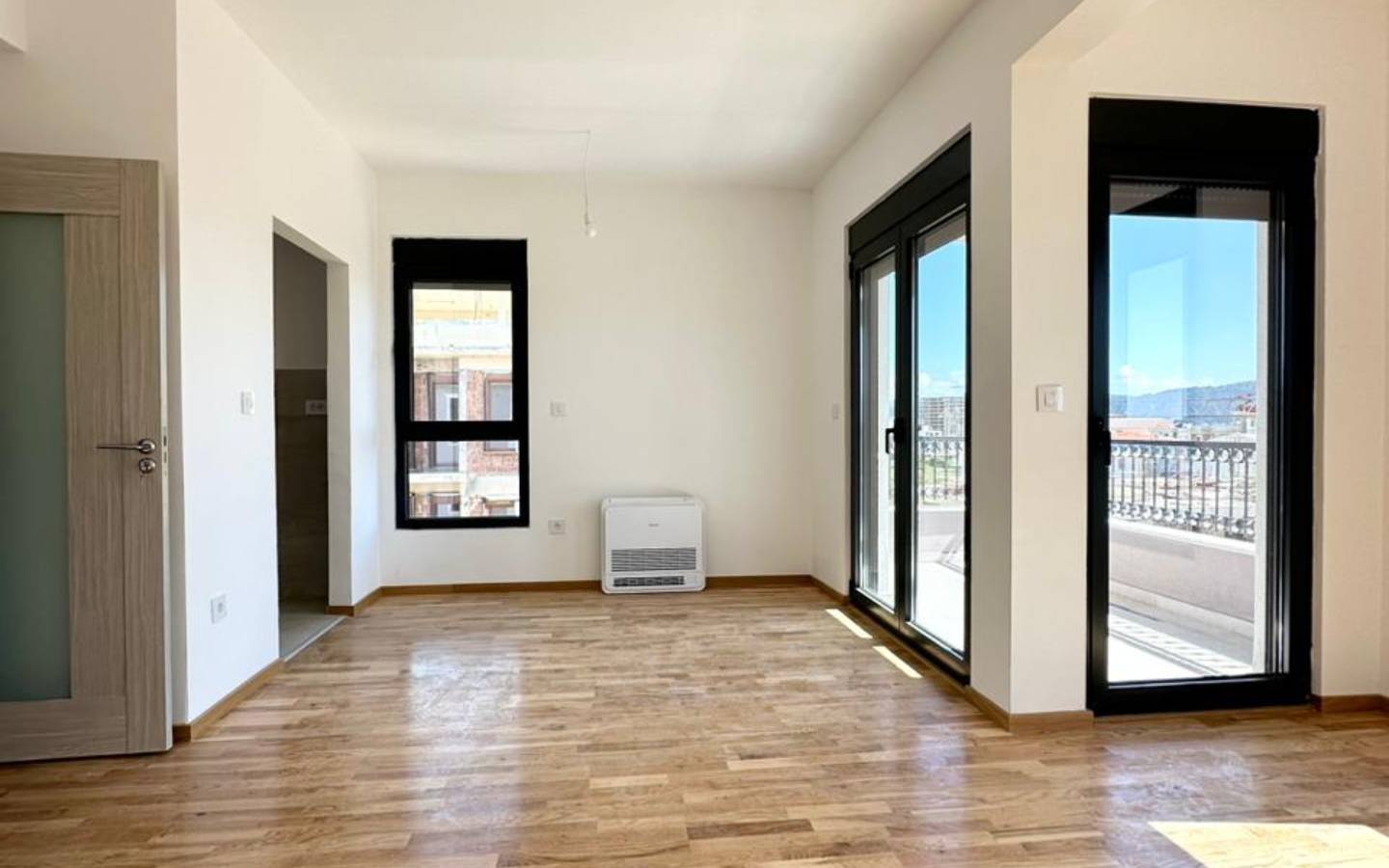 Spacious sunlit room with sleek floors, panoramic balcony views in Ulcinj&mdash;prime Montenegro real estate via immobilien.ekosphere.me by ekosphere doo.