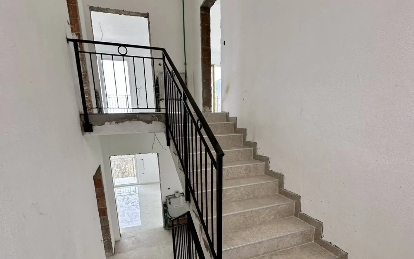 Modern stairway with beige steps and black railing in an Ulcinj property&acirc;prime investment from ekosphere doo via immobilien.ekosphere.me.