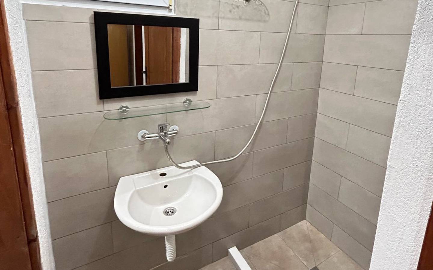 Elegant Ulcinj bathroom with modern fixtures, beige tile, and stylish details&mdash;exclusive on immobilien.ekosphere.me by Ekosphere doo.