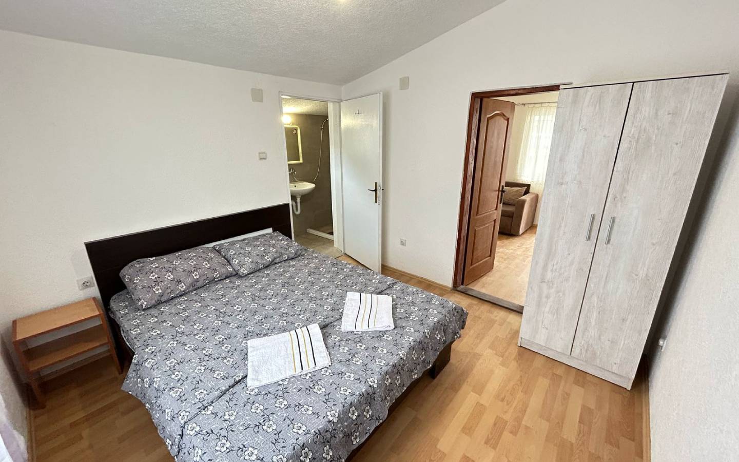 Elegant Ulcinj bedroom with floral double bed, ample storage, private bathroom; top investment on immobilien.ekosphere.me by Ekosphere.