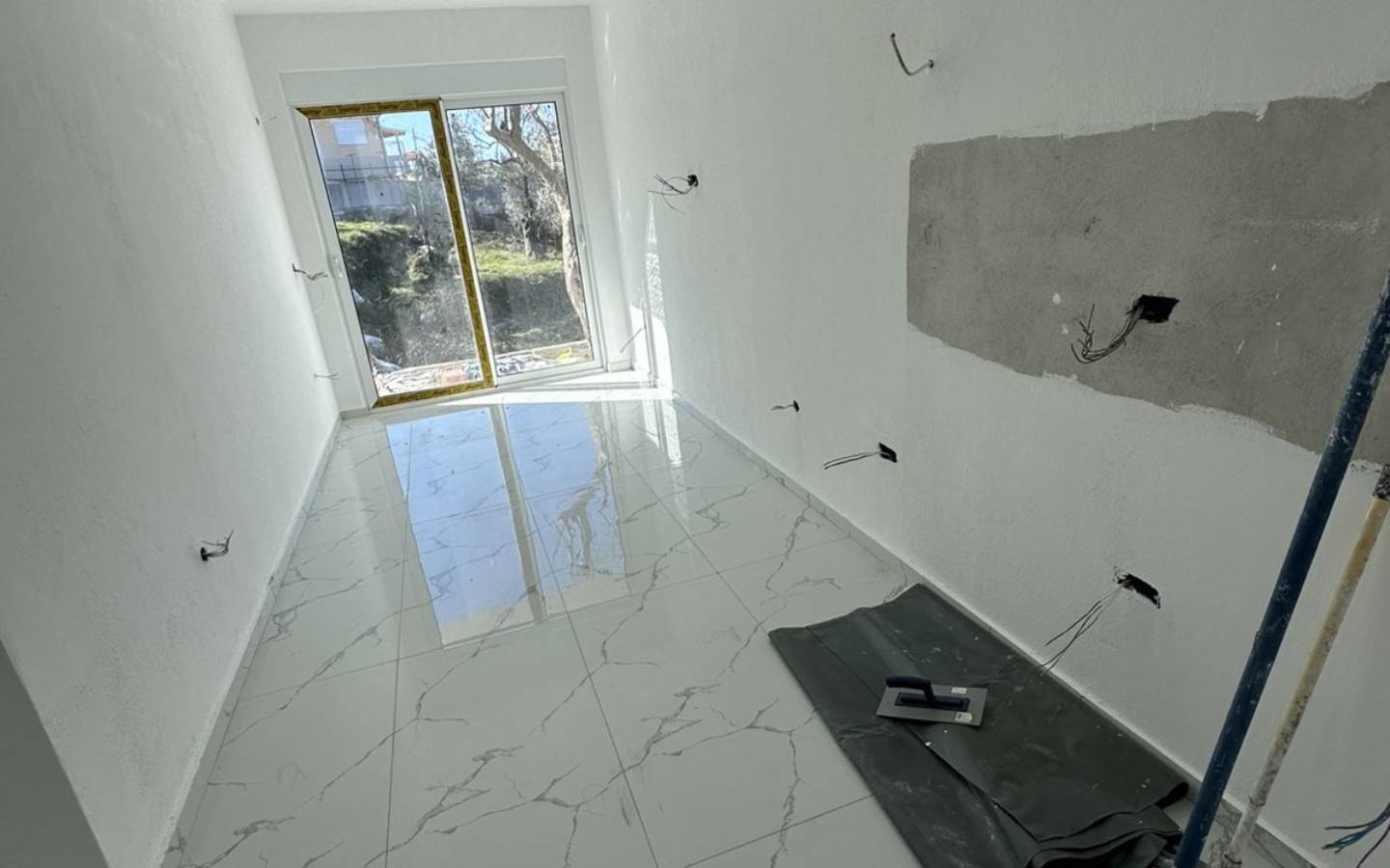 Renovation-ready room in Ulcinj, Montenegro; bright white walls, tiled flooring, glass doors&acirc;prime investment at immobilien.ekosphere.me by Ekosphere doo.