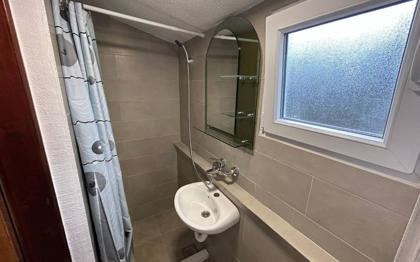 Modern Ulcinj bathroom with beige tiles, quality fixtures, and glass shelves&mdash;exclusive listing by ekosphere doo at immobilien.ekosphere.me.