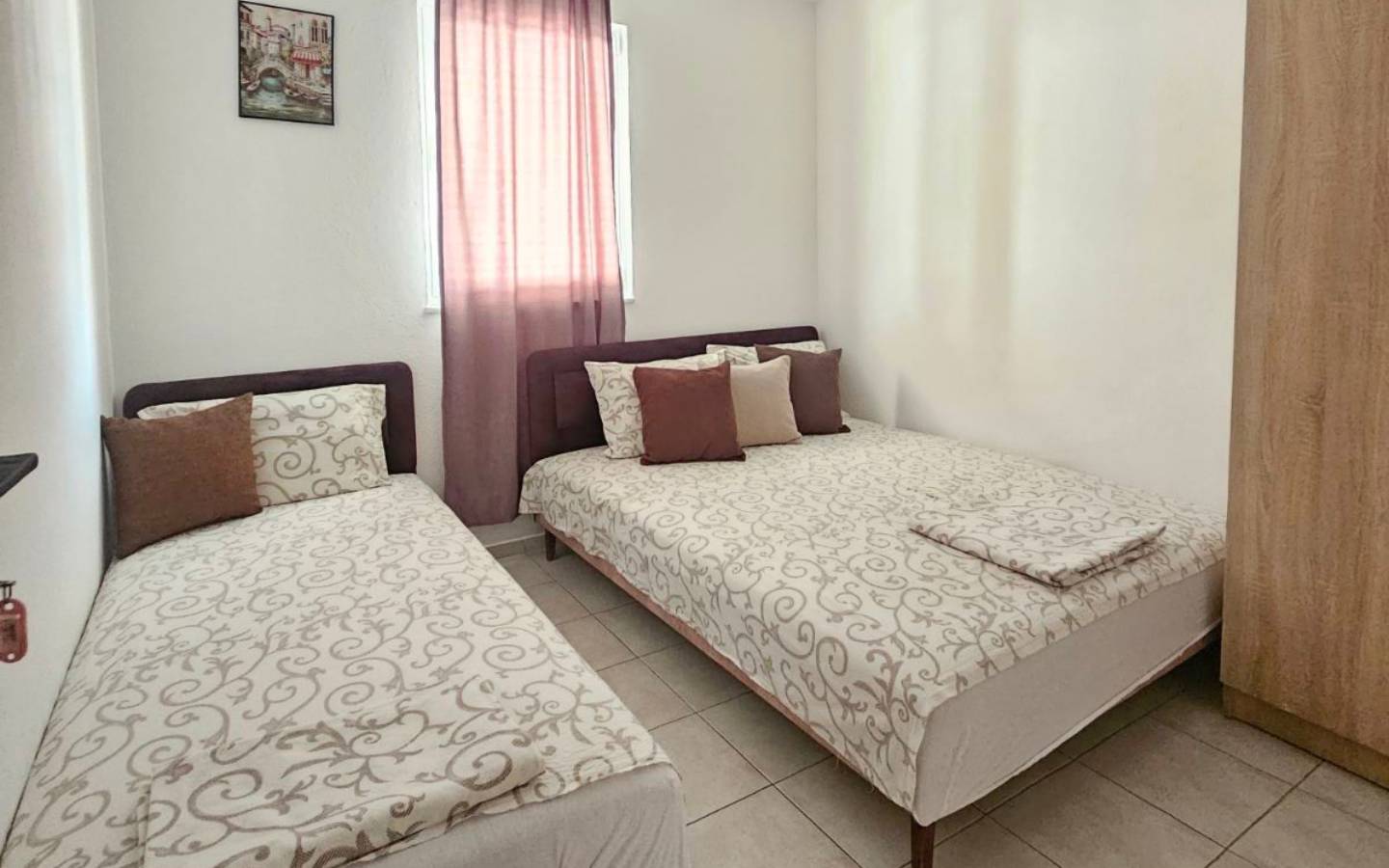 Stylish Ulcinj bedroom for sale: double & single beds, wood wardrobe, modern d&eacute;cor&mdash;prime real estate by immobilien.ekosphere.me/Ekosphere.