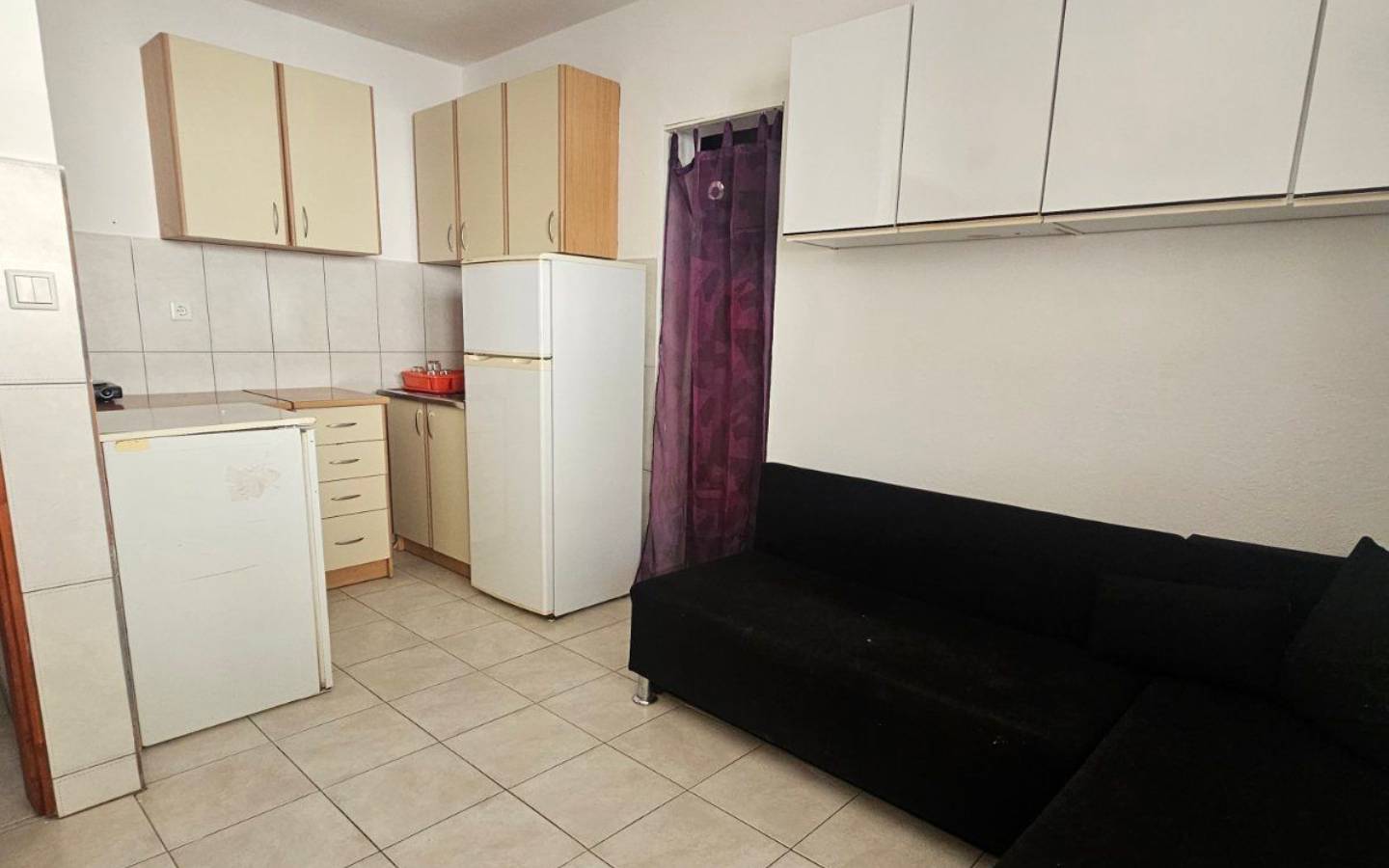 Modern Ulcinj apartment: light cabinets, tiled floors, L-shaped sofa. Invest in eco-friendly living&mdash;immobilien.ekosphere.me by ekosphere doo.