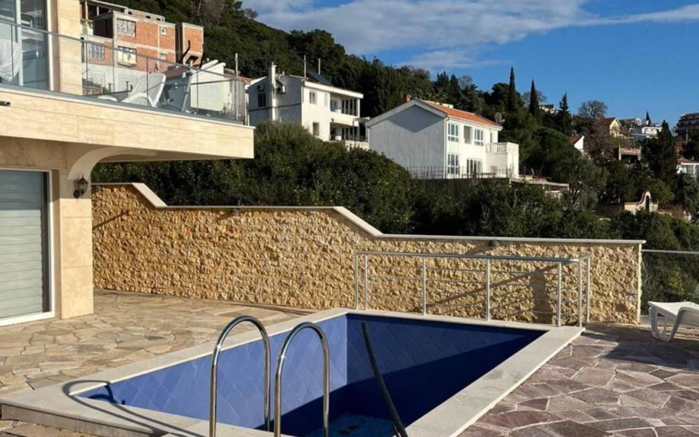 Stunning Ulcinj villa with private pool on a stone patio, glass railing, hillside views. Prime Montenegro investment via ekosphere doo.