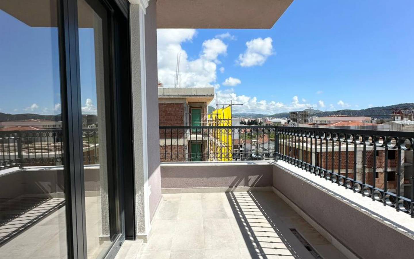 Modern tiled balcony with sleek railing, city views, and investment potential in Ulcinj, Montenegro. By Ekosphere DOO on immobilien.ekosphere.me.