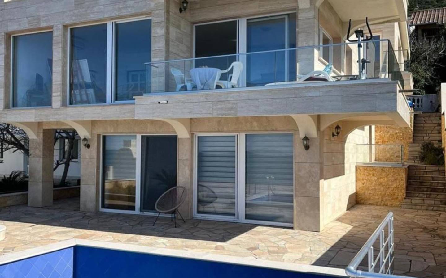Contemporary two-story home in Ulcinj, Montenegro with glass doors, balcony, stone patio, pool&mdash;prime investment via immobilien.ekosphere.me.