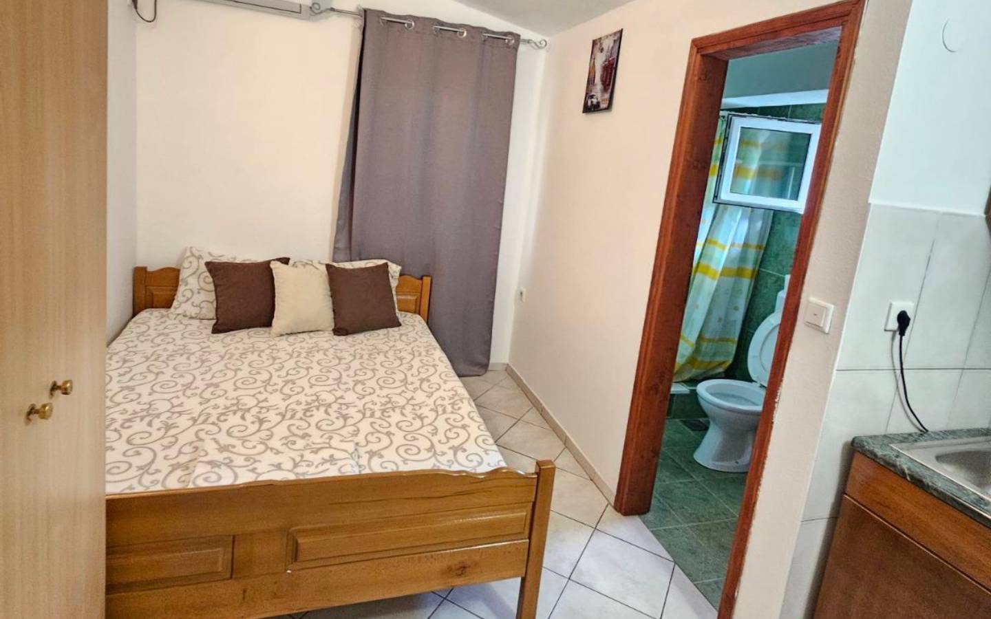 Modern Ulcinj Montenegro bedroom with stylish wooden bed, wardrobe, ensuite bath&mdash;ideal real estate investment by ekosphere doo.