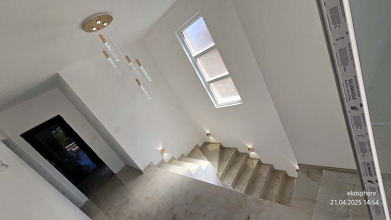 Elegant staircase with beige steps, chic lights, and tall window&mdash;ideal Ulcinj investment, listed by immobilien.ekosphere.me (ekosphere doo).