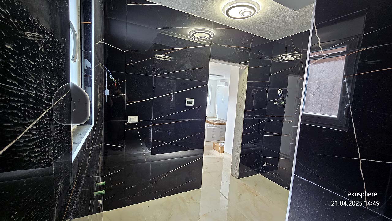 Contemporary room with black marble walls, window, and doorway to bright space. Prime Ulcinj real estate&mdash;immobilien.ekosphere.me by ekosphere doo.