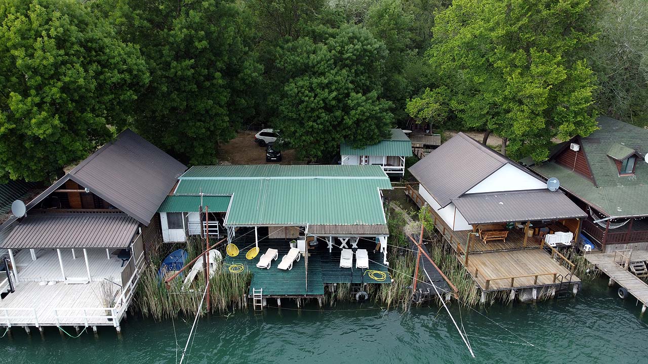 Stunning Ulcinj riverfront cabins with private decks, lush greenery; exclusive investment via immobilien.ekosphere.me by Ekosphere Doo.