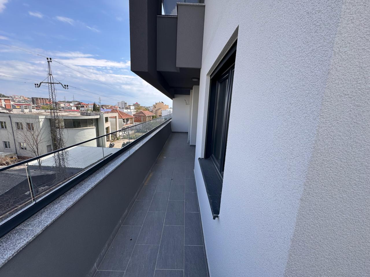 Modern balcony with glass railing and gray tiles, prime Ulcinj real estate; great views&mdash;exclusive on immobilien.ekosphere.me by ekosphere doo.