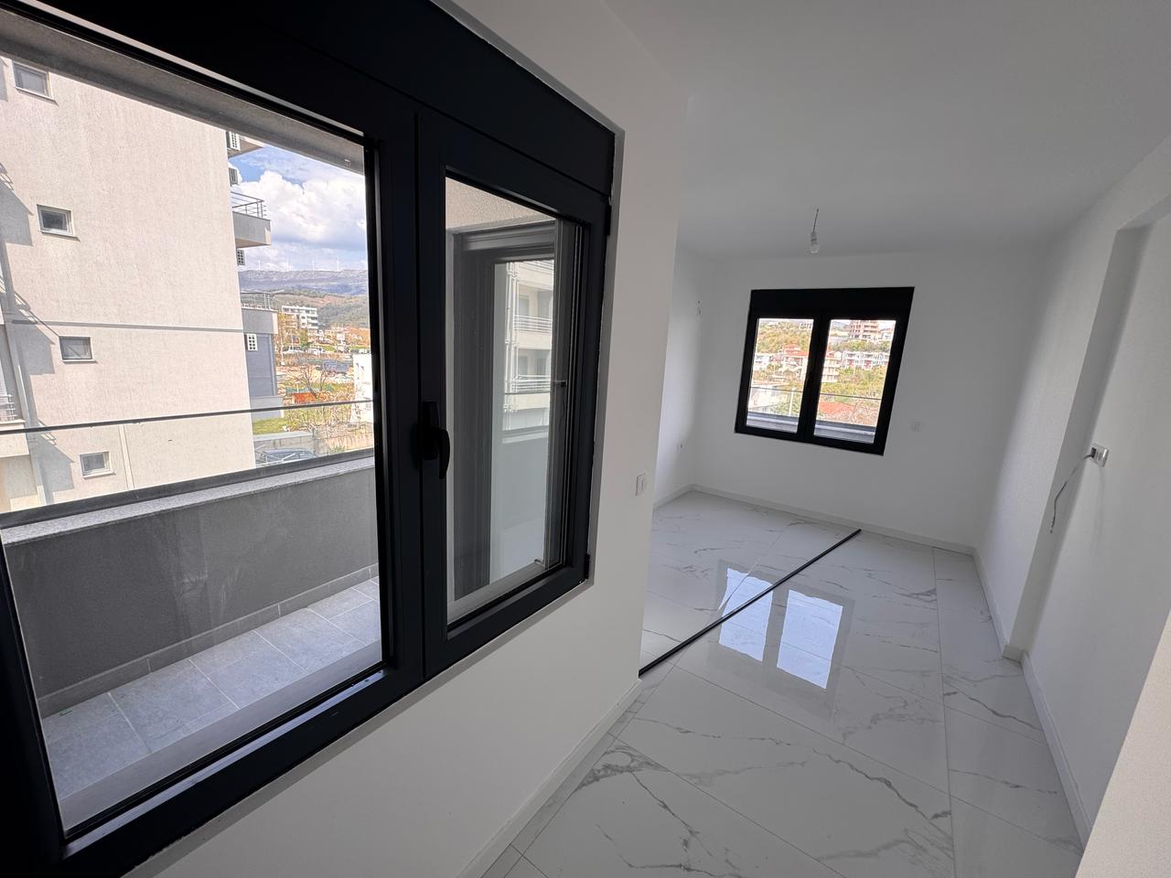 Spacious, sunlit room with white walls, marble floors, balcony views&mdash;prime Ulcinj real estate from immobilien.ekosphere.me by Ekosphere.