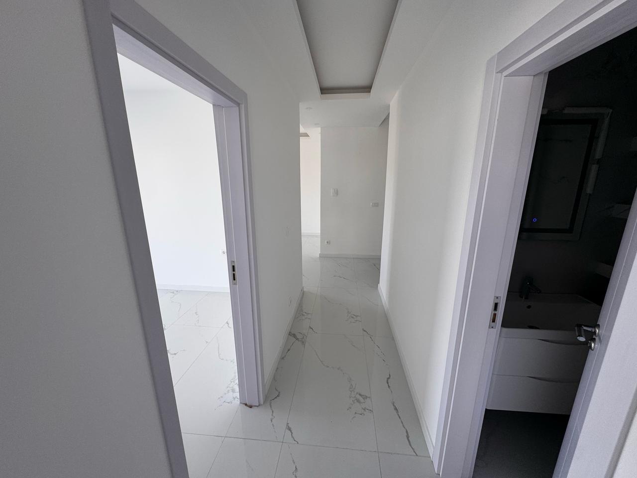 Modern hallway in eksosphere-designed Ulcinj property with marble floors, white walls, 2 rooms. Exclusive on immobilien.ekosphere.me.