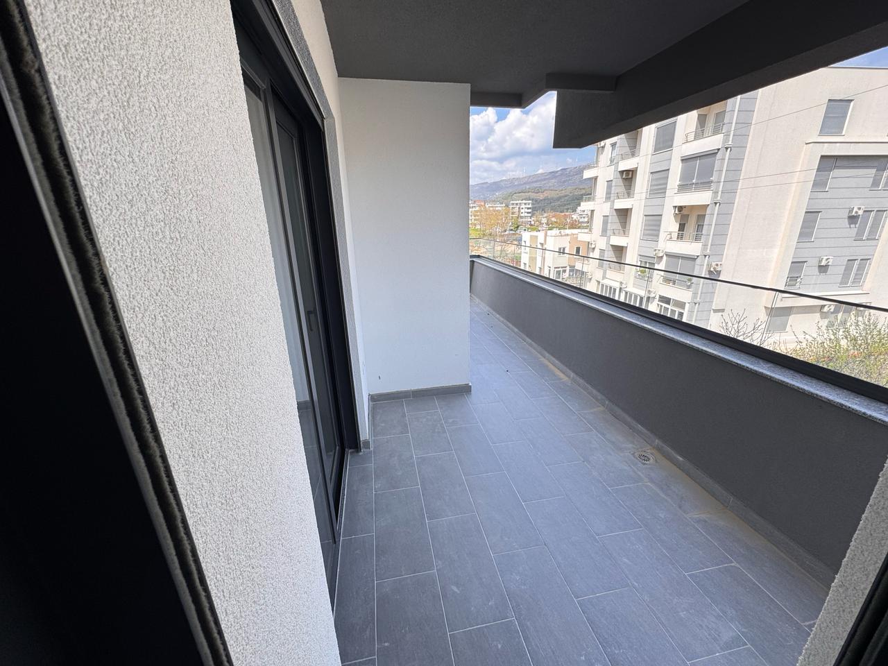 Stylish Ulcinj balcony with gray tiles, glass door, private wall; invest in Montenegro real estate via immobilien.ekosphere.me by ekosphere doo.