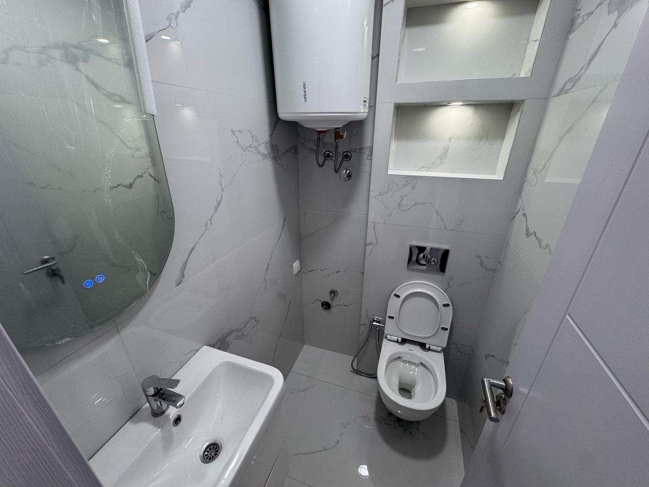 Elegant modern bathroom in Ulcinj with marble tiles, wall fixtures, built-ins&mdash;exclusive on immobilien.ekosphere.me by ekosphere doo.