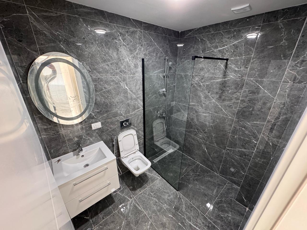 Luxurious Ulcinj property: elegant bathroom with marble, walk-in shower, and chic vanity&mdash;immobilien.ekosphere.me by Ekosphere DOO.
