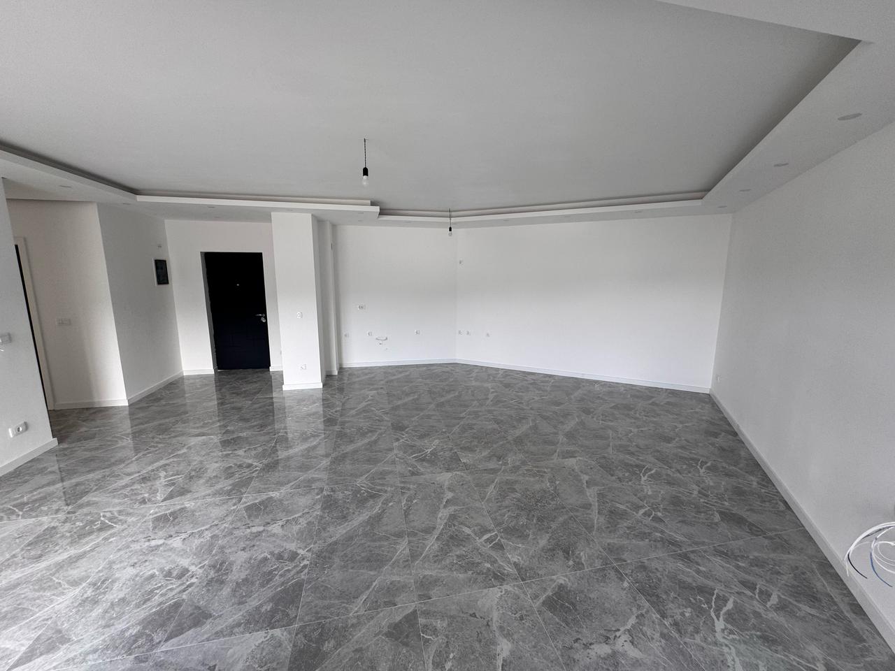 Discover a prime Ulcinj, Montenegro property: modern room with white walls, marbled tiles, & ekosphere style&mdash;exclusive at immobilien.ekosphere.me.
