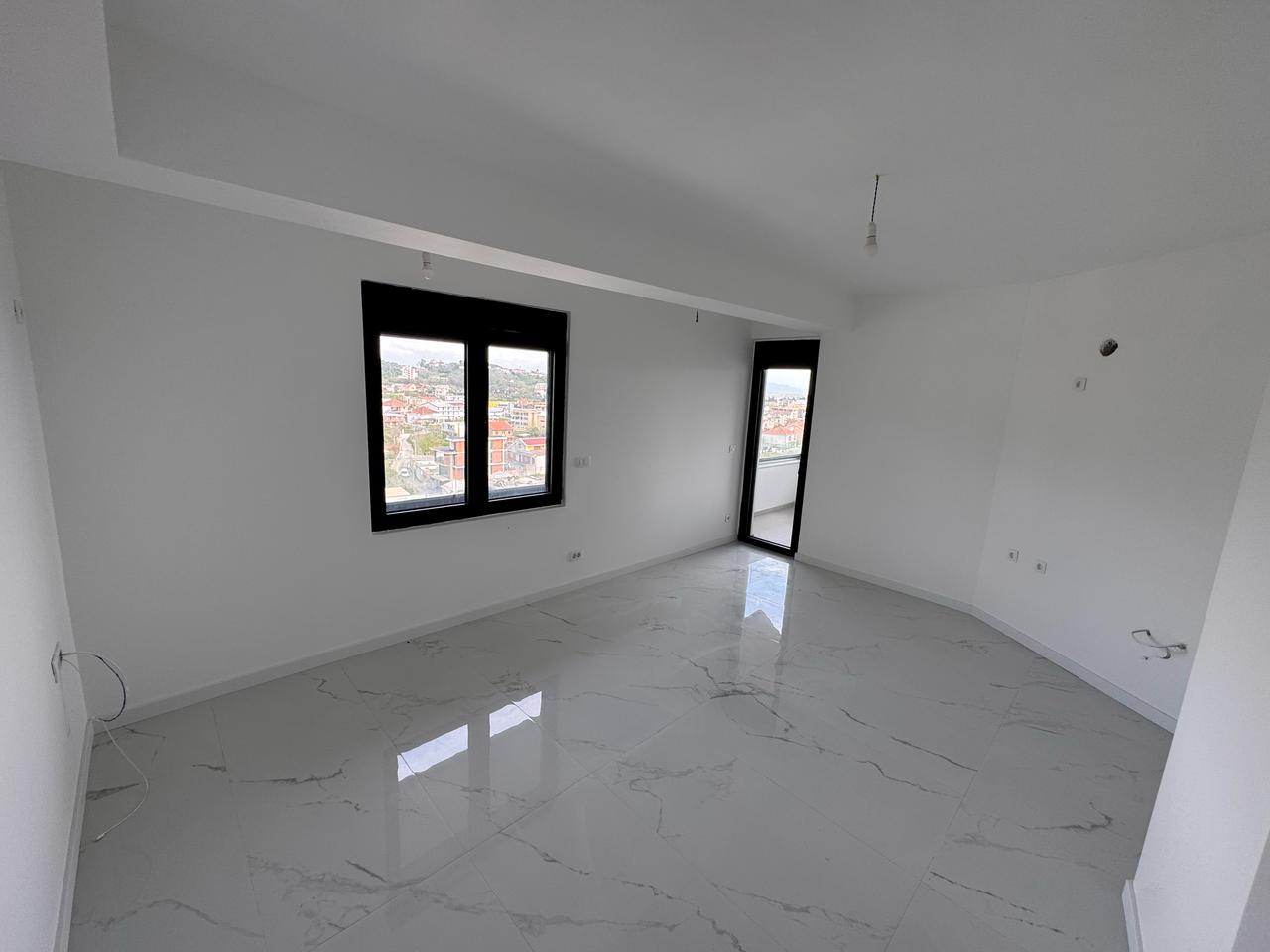 Modern Ulcinj property: bright room, marble tiles, stylish black windows. Prime investment by ekosphere doo at immobilien.ekosphere.me.