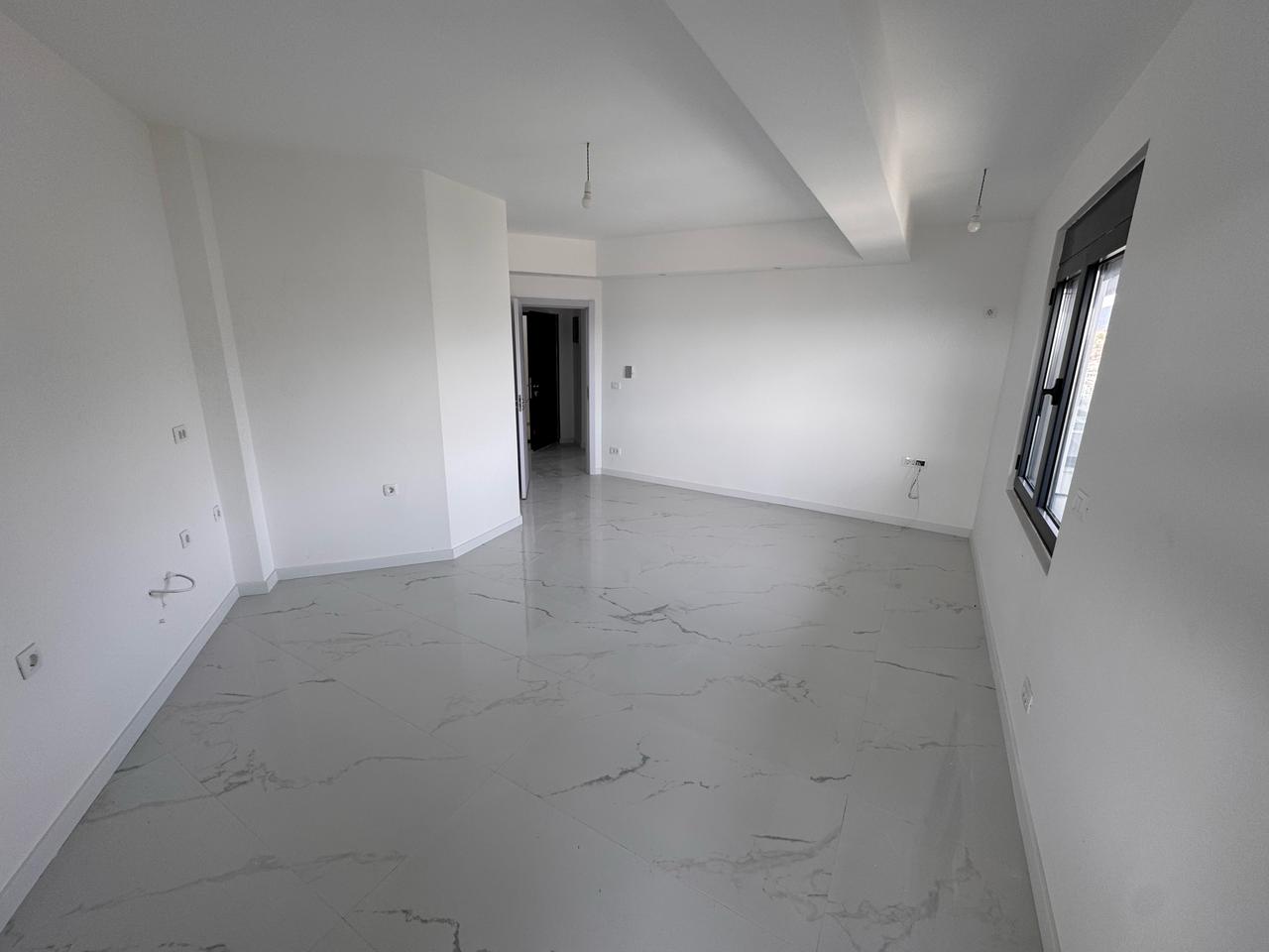 Bright, spacious room with white walls and marble tiles&mdash;prime Ulcinj real estate by ekosphere doo. Ideal property investment.