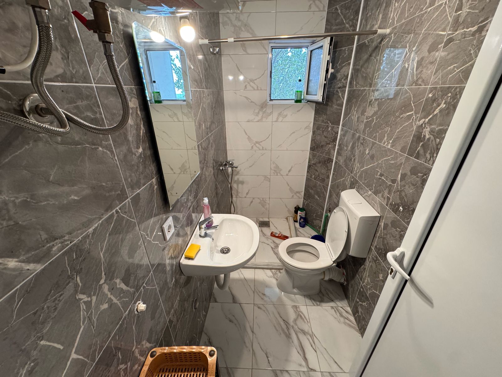 Modern Ulcinj property bathroom with marble tiles, windows, wall-mount sink; listed on immobilien.ekosphere.me by ekosphere doo.