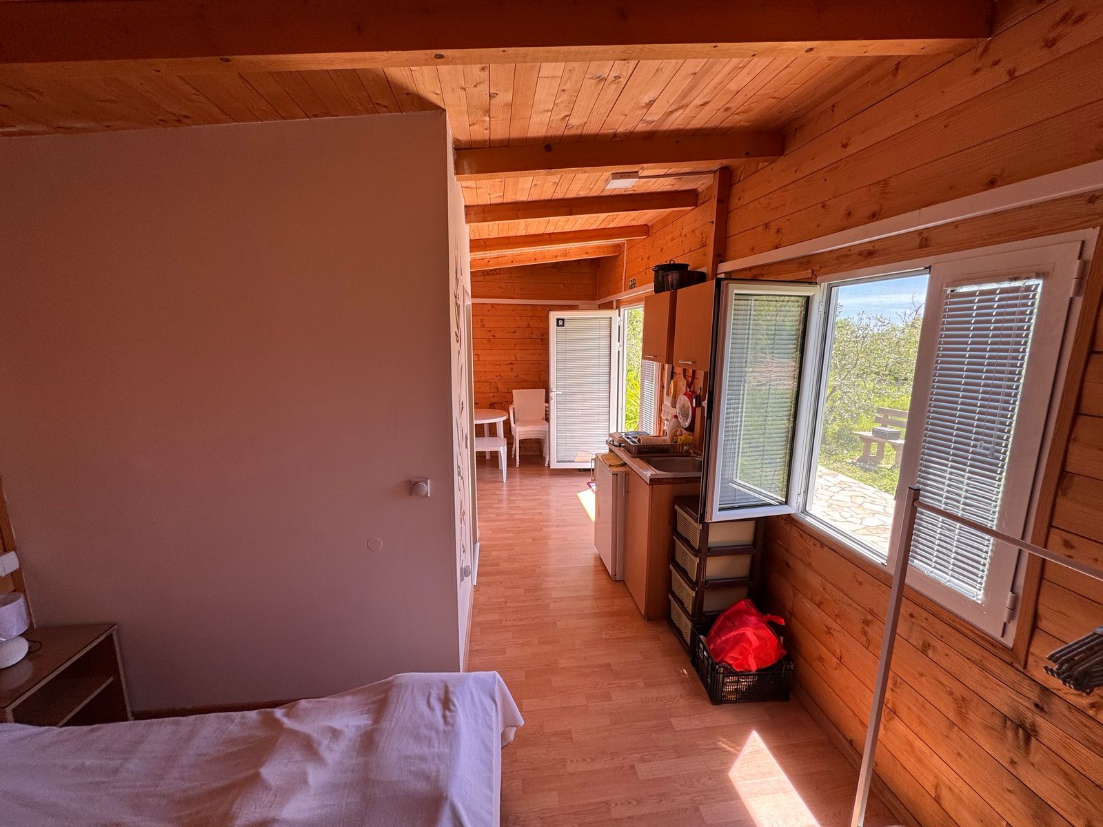 Charming wooden cabin in Ulcinj, Montenegro: cozy bed, sunlit interior, ideal investment via immobilien.ekosphere.me by Ekosphere.
